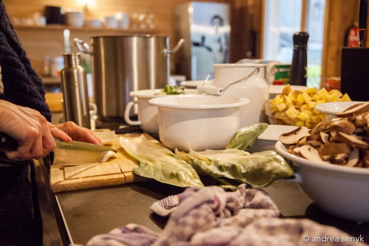 Köchin bereitet vegetarisches Essen in Emaille-Töpfen zu