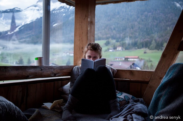 Frau liest vor Bergpanorama