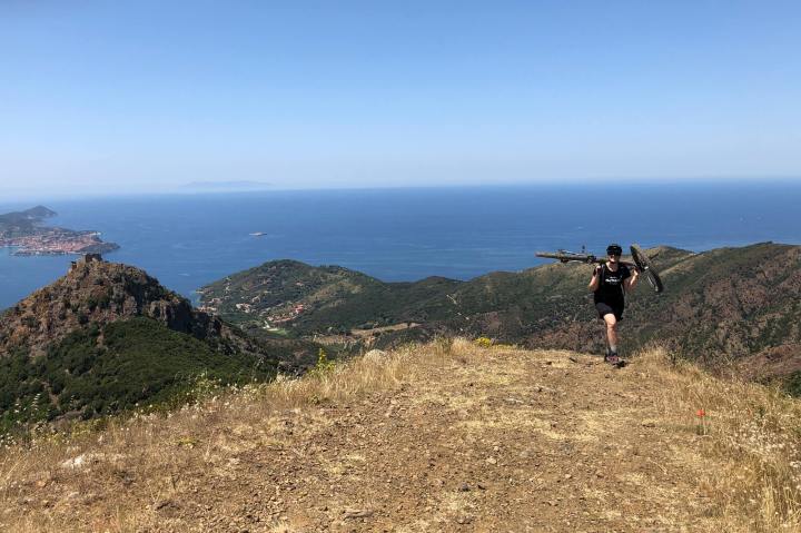 Frau trägt Mountainbike auf Berg